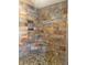 The corner shower displays beautiful stonework, pebble flooring, a built-in seat, and a convenient storage niche at 5607 E 500 N, Greenfield, IN 46140
