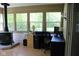 Sunroom featuring multiple windows, wood burning stove and desk area at 5607 E 500 N, Greenfield, IN 46140