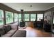 Sunroom featuring wood burning stove, large windows, and desk workspace at 5607 E 500 N, Greenfield, IN 46140