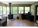 Sunroom features many windows, a wood burning stove, and an office setup at 5607 E 500 N, Greenfield, IN 46140