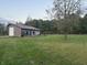 View of the yard and home, with a garage door on the left and a tree to the right at 5607 E 500 N, Greenfield, IN 46140