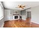 Open living room featuring hardwood floors, a fireplace with a wooden mantle, and a ceiling fan at 5846 Linton Ln, Indianapolis, IN 46220