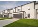 Row of new townhomes featuring two-car garages, grass yards and black trim at 6216 Cascades Dr, Whitestown, IN 46075