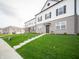 Well-maintained townhouse exterior with a lush green lawn and convenient walkway access at 6216 Cascades Dr, Whitestown, IN 46075