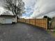View of long wood fence stretching across a large lot with a detached garage and freshly paved parking area at 647 N 100 W, Franklin, IN 46131