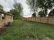A fully fenced-in grassy backyard with brick house and cooling system at 647 N 100 W, Franklin, IN 46131