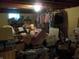 Basement storage area with clothing rack, boxes, and disorganized contents at 6736 E Michigan St, Indianapolis, IN 46219