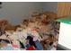 The bedroom has an unmade bed and clutter piled up near the headboard and side table at 6736 E Michigan St, Indianapolis, IN 46219