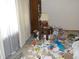 A bedroom shows a bedside table and a lamp among items scattered on the floor at 6736 E Michigan St, Indianapolis, IN 46219