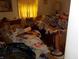 The bedroom has items on the bed, floor, and side tables with yellow curtains on the window at 6736 E Michigan St, Indianapolis, IN 46219