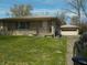 Inviting single-story home with stone facade, well-maintained lawn and landscaping plus a detached one car garage at 6736 E Michigan St, Indianapolis, IN 46219