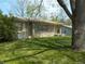Attractive stone-clad single-story house with mature tree and landscaped yard, offering a classic and cozy curb appeal at 6736 E Michigan St, Indianapolis, IN 46219