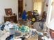 The living room shows clutter and a dining table with various items scattered around at 6736 E Michigan St, Indianapolis, IN 46219