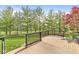 A wooden back deck overlooks a spacious, green backyard lined with mature trees and fencing at 6758 Woodcliff Cir, Zionsville, IN 46077