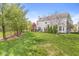 Exterior of home with a large backyard, mature trees, and a deck, perfect for outdoor activities at 6758 Woodcliff Cir, Zionsville, IN 46077