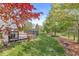 Spacious backyard with a wooden deck, mature trees, and green lawn at 6758 Woodcliff Cir, Zionsville, IN 46077