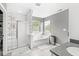 Modern bathroom with glass block shower, soaking tub, and tile flooring with ample natural light at 6758 Woodcliff Cir, Zionsville, IN 46077