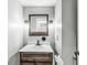 Charming powder room featuring a vessel sink, decorative mirror, and industrial-style sconces at 6758 Woodcliff Cir, Zionsville, IN 46077