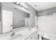 Bright bathroom featuring a double sink vanity, large mirror, and shower-tub combo with curtain at 6758 Woodcliff Cir, Zionsville, IN 46077