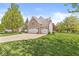 Attractive home featuring a brick facade, a well-kept lawn, and a long driveway at 6758 Woodcliff Cir, Zionsville, IN 46077