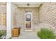 Close-up of a brick-covered front porch showing the detailed door, brickwork, and plants at 6758 Woodcliff Cir, Zionsville, IN 46077
