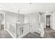 Upstairs hallway with carpet, white railings, and a decorative light fixture at 6758 Woodcliff Cir, Zionsville, IN 46077
