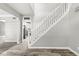 Staircase view from bottom with hardwood-style flooring, white trim, and adjacent kitchen at 6758 Woodcliff Cir, Zionsville, IN 46077