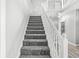 Carpeted stairway with white wood railings and decorative posts leading to upper level at 6758 Woodcliff Cir, Zionsville, IN 46077
