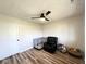 Bedroom featuring a black recliner, a dog crate, and wood-look flooring at 6811 S Meridian St, Indianapolis, IN 46217