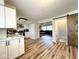 Modern kitchen features white cabinets, wood floors, and sliding barn door to basement stairs at 6811 S Meridian St, Indianapolis, IN 46217