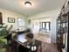 Well-lit home office space featuring a large desk, hardwood floors, and decorative shelving at 6811 S Meridian St, Indianapolis, IN 46217