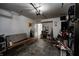 View of the cluttered garage with an open door leading outside at 6814 Summer Time Dr, Indianapolis, IN 46226