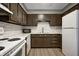 Well-lit kitchen features white appliances, marbled backsplash and dark brown cabinetry at 6814 Summer Time Dr, Indianapolis, IN 46226