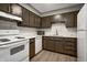 Well-lit kitchen features white appliances, marbled backsplash and dark brown cabinetry at 6814 Summer Time Dr, Indianapolis, IN 46226