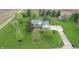 Aerial view of a beautiful blue home with a large yard, long driveway, and lush greenery at 7020 N 375 E, Lebanon, IN 46052