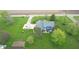 Aerial view of the back of a blue home featuring a stone patio, hot tub, lush landscaping, and large yard at 7020 N 375 E, Lebanon, IN 46052