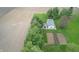 Aerial view of an outbuilding and garden with a surrounding tree line and farm fields at 7020 N 375 E, Lebanon, IN 46052
