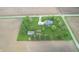 Expansive aerial view of a blue home with a large, well-maintained yard, garden, and outbuilding, surrounded by farm fields at 7020 N 375 E, Lebanon, IN 46052