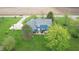 Aerial view of the back of a blue home featuring a stone patio, hot tub, lush landscaping, and large yard at 7020 N 375 E, Lebanon, IN 46052