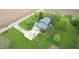 Aerial view of a blue home with a long driveway and mature trees, surrounded by a green lawn and farmland at 7020 N 375 E, Lebanon, IN 46052