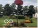 Backyard view with basketball hoop surrounded by well-maintained lawn and vibrant flowerbeds at 7020 N 375 E, Lebanon, IN 46052
