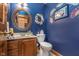 Cozy half-bathroom with blue walls, decorative mirror, and classic fixtures at 7020 N 375 E, Lebanon, IN 46052
