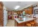 Bright kitchen featuring wooden cabinets, tile floor, and a breakfast bar with seating for three at 7020 N 375 E, Lebanon, IN 46052