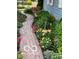 Charming brick pathway lined with vibrant flowers and lush greenery adds curb appeal at 7020 N 375 E, Lebanon, IN 46052