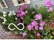 Exterior shot showcasing colorful flowers and green foliage with brick trim at 7020 N 375 E, Lebanon, IN 46052