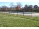 Community pool surrounded by lush green space and a secure fence at 7404 Countrybrook Dr, Indianapolis, IN 46260