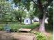 Spacious deck with seating overlooking the lush, tree-filled backyard and shed at 8728 Holliday Dr, Indianapolis, IN 46260