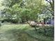 Lush backyard featuring a mature tree, well-manicured lawn and a charming deck at 8728 Holliday Dr, Indianapolis, IN 46260