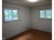 Bright bedroom featuring hardwood floors and natural light streaming through two windows at 8728 Holliday Dr, Indianapolis, IN 46260