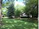 Charming single-story home surrounded by mature trees and a green lawn at 8728 Holliday Dr, Indianapolis, IN 46260